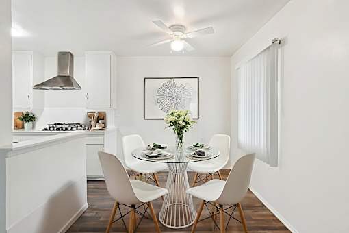 A modern kitchen with a dining table set for four.