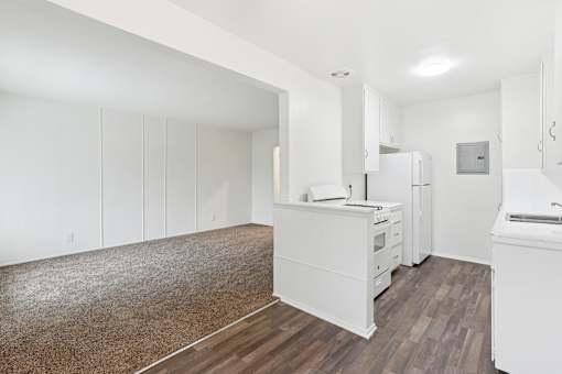 A kitchen with white cabinets and a white fridge.