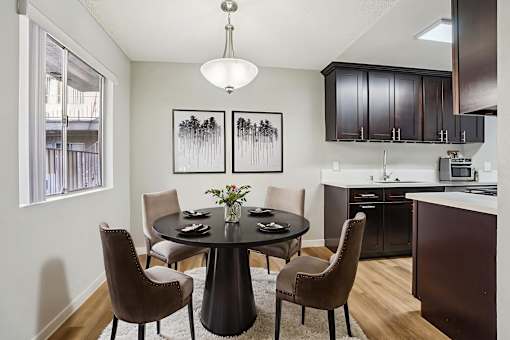 A modern dining room with a round table and chairs.