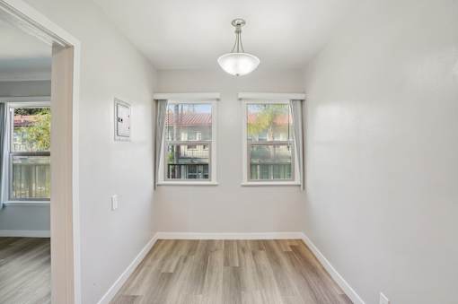 A room with a window and a wooden floor.