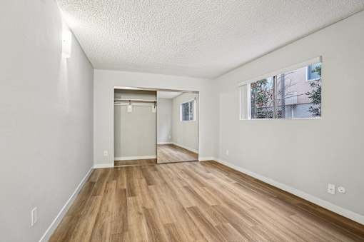 A room with wooden flooring and white walls.