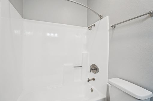A white bathroom with a toilet and a shower.