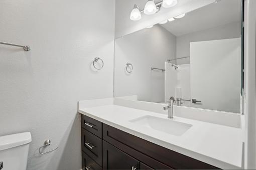 A white sink in a bathroom with a mirror above it.