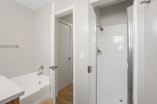 A white bathroom with a tub and shower.