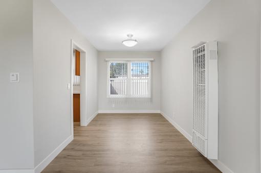 A long, empty hallway with a window and a door.