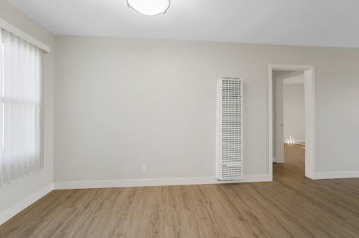 A room with a white wall and a white air conditioner unit.