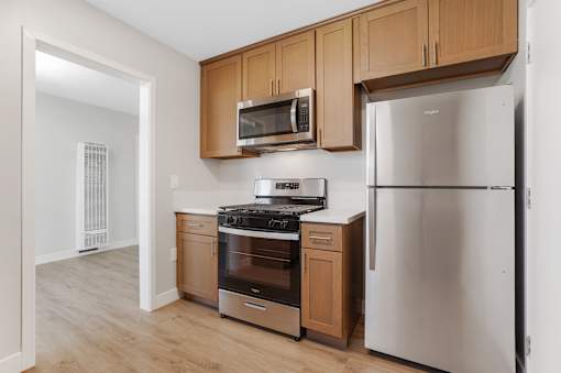 A kitchen with a stove, oven, refrigerator, and microwave.