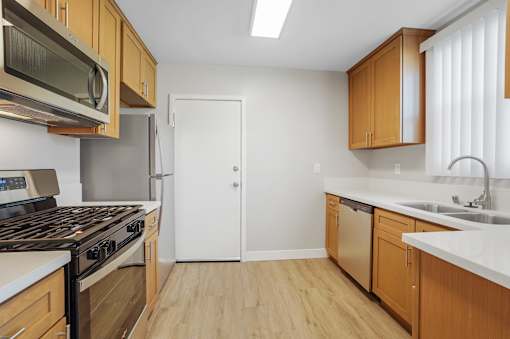 A kitchen with wooden cabinets and a white door.