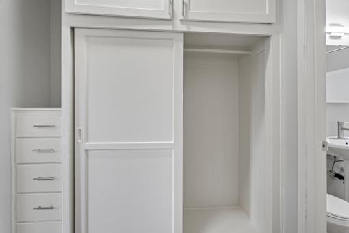 A white cabinet with a door is open.