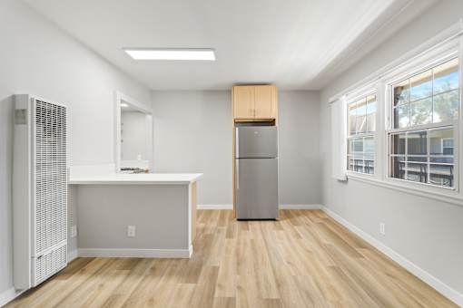 A kitchen with a refrigerator, a sink, and a window.