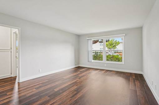A room with a window and wooden flooring.