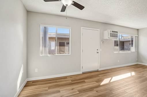 A room with a ceiling fan and a window with a view of a building.