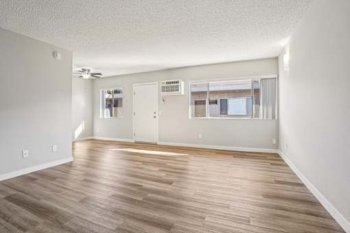 A room with wooden flooring and white walls.