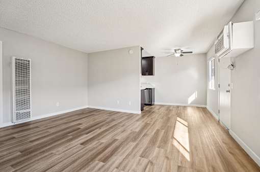 A room with wooden flooring and white walls.