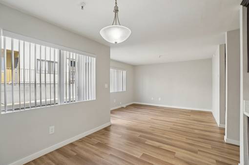 A room with wooden floors and a hanging light fixture.