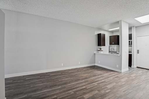A room with wooden flooring and white walls.