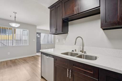 A kitchen with a white counter top and brown cabinets.