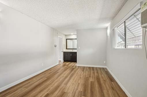 A room with wooden flooring and white walls.