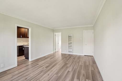 A room with wooden flooring and white walls.