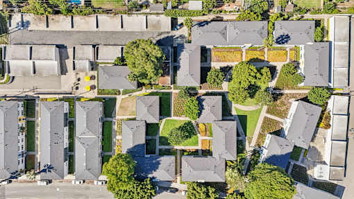 A bird's eye view of a residential area with houses and a park.