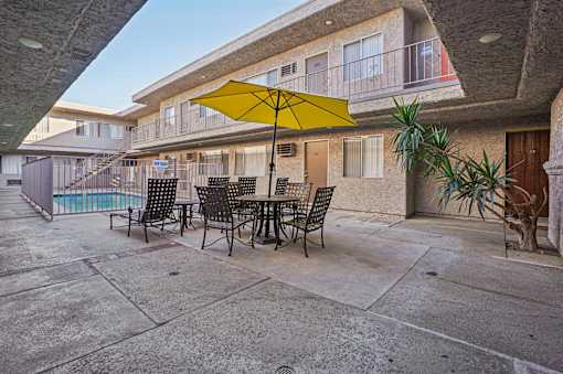 A yellow umbrella is on a table outside a building.