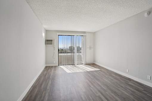 A room with a sliding glass door leading to a balcony.