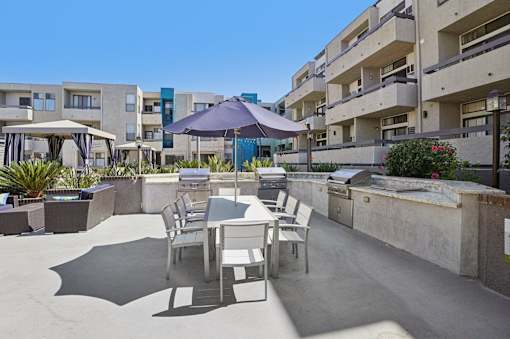 A patio with a table and chairs is surrounded by buildings.