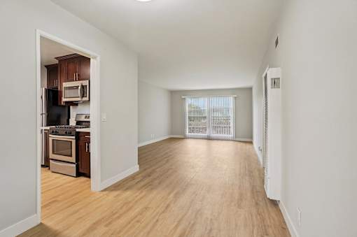 A kitchen with wooden floors and white walls.