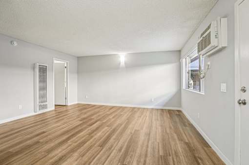 A room with wooden flooring and white walls.