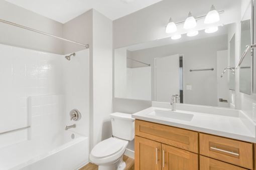A white bathroom with a toilet, sink, and bathtub.