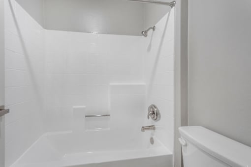 A white bathroom with a tub and shower.