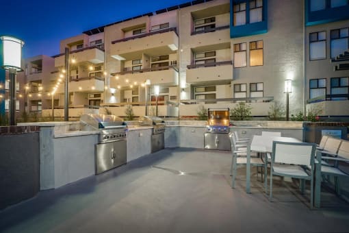 a patio with a table and chairs in front of an apartment building