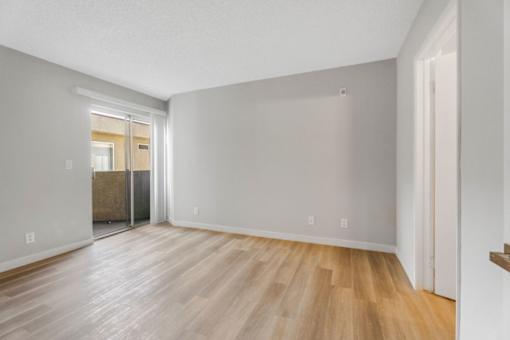 A room with wooden flooring and white walls.