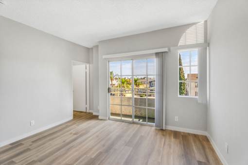 A room with a sliding glass door leading to a balcony.