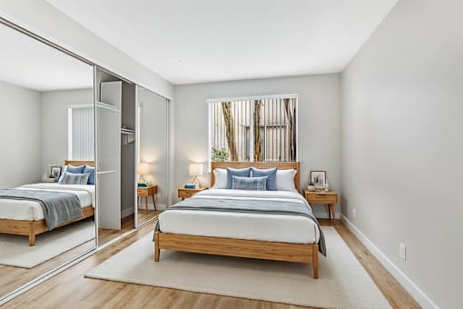 A bedroom with a large bed and a mirror on the wall.
