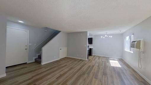 A room with wooden flooring and white walls.