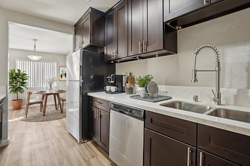 A modern kitchen with dark brown cabinets and stainless steel appliances.