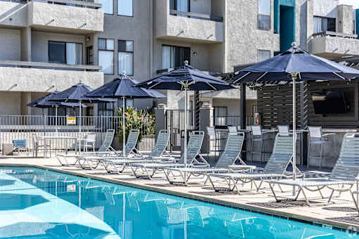 a pool with lounge chairs and umbrellas at a hotel