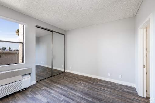 an empty living room with wood flooring and a window