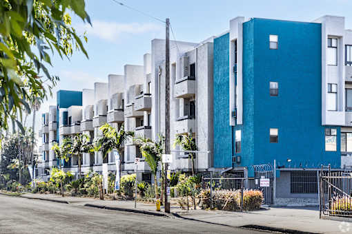 a blue and white apartment building on a city street