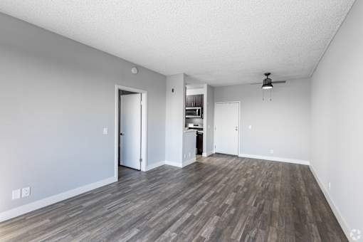 an empty living room with a hard wood floor and white walls