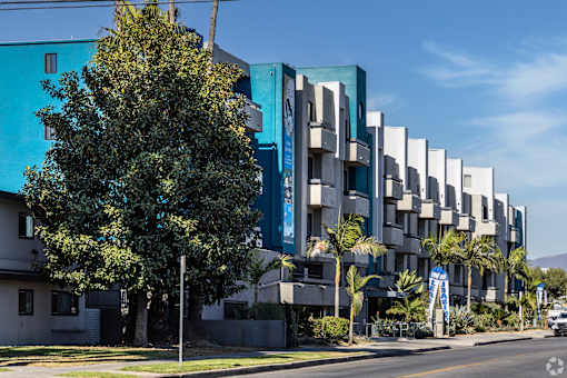 a large blue building with a tree in front of it