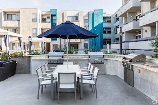 a patio with an umbrella and a table with chairs