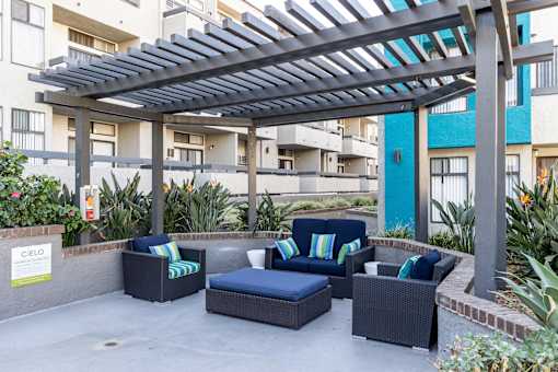 a patio with couches and chairs under awning