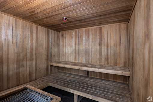 a wooden sauna with two benches and a grate