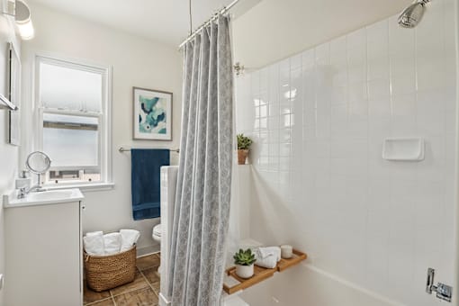 A bathroom with a white shower curtain and a white sink.