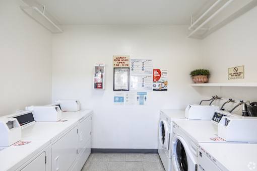 A laundromat with washers and dryers and a sign that says
