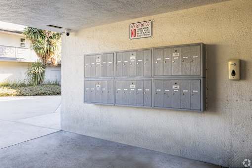 A wall with a sign that says "No Parking" and a row of electrical boxes.