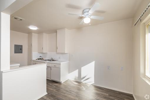 A white kitchen with a fan on the ceiling.