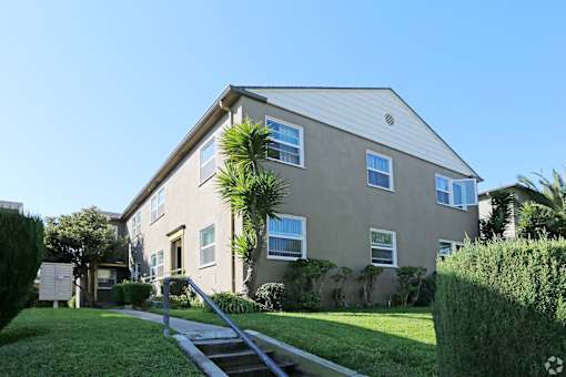 A house with a grey roof and a green lawn in front.